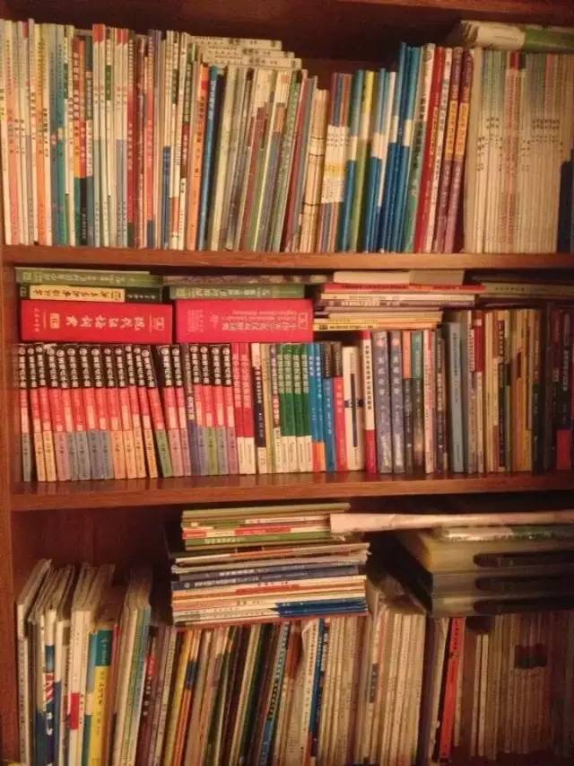 图片中,李华高中时期的学习辅导书和作业本,堆满了整座书架.