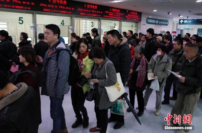 图:民众正在上海交通大学医学院附属仁济医院东院门诊楼内排队挂号