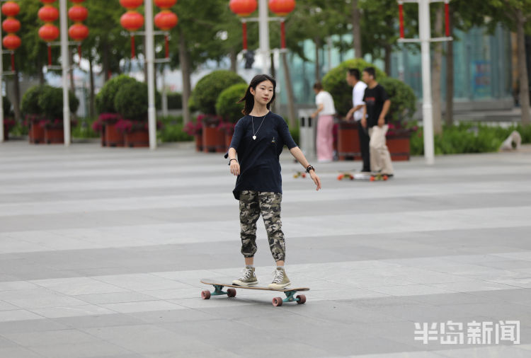 青岛澳门路一广场上滑板少年炫酷动作吸引路人目光