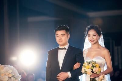 她来自泸州,照片中,她穿着露肩婚纱,挽着老公的手,露齿微笑.