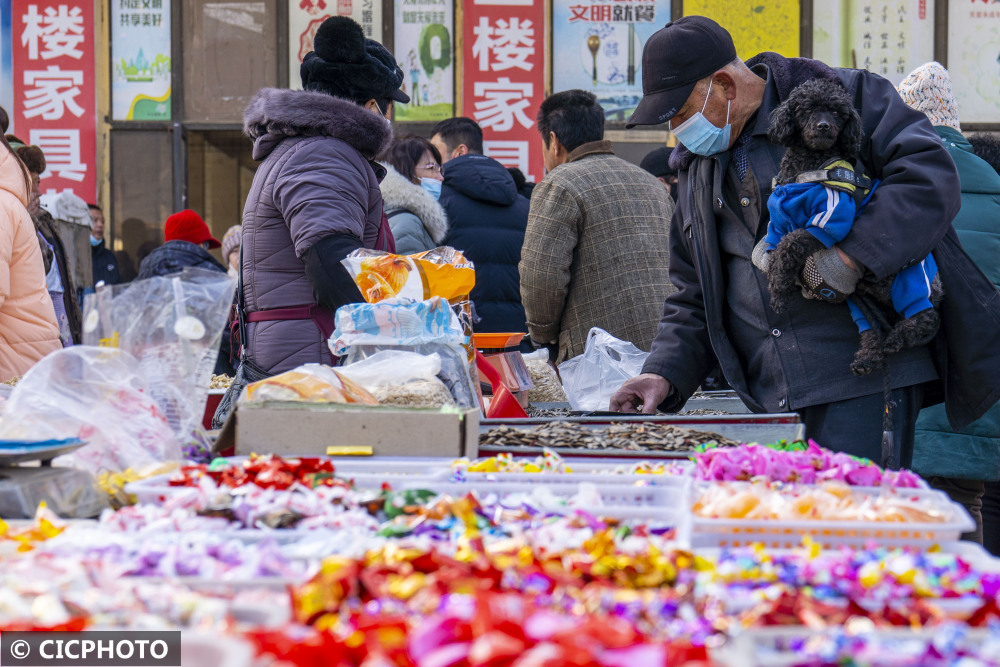 2022年1月24日,人们在河北省秦皇岛市北戴河区牛头崖大集挑选糖果