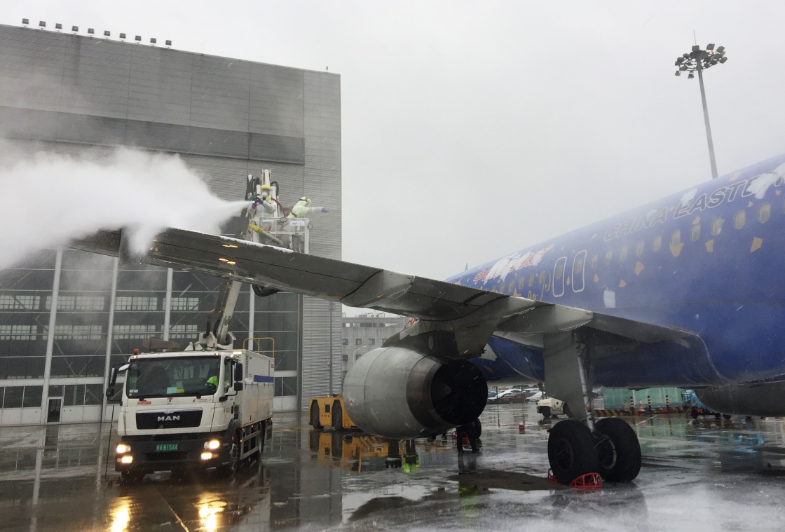 1月25日,上海虹橋機場的地勤人員在為大型客機除冰雪.