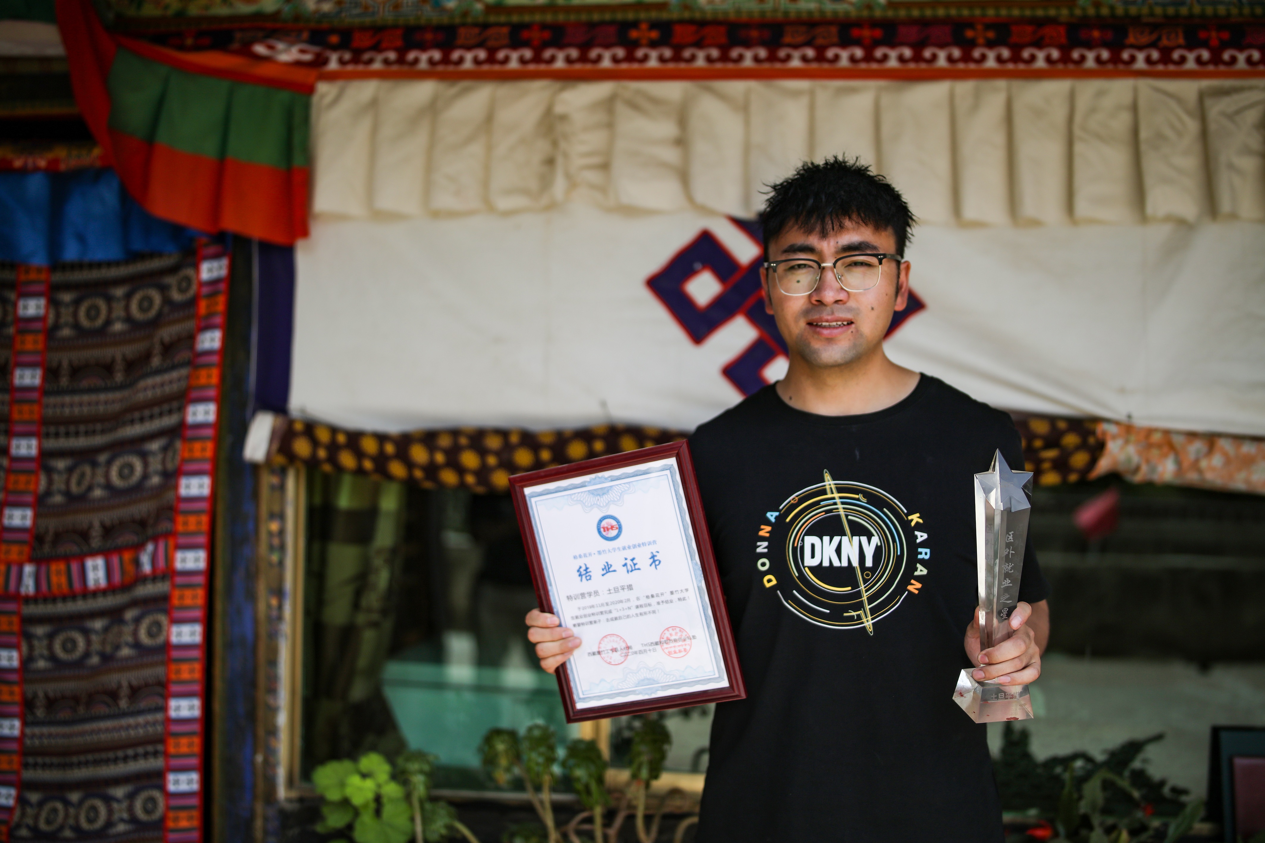 土旦平措展示特训营结业证书和"区外就业之星"奖杯(6月23日摄).