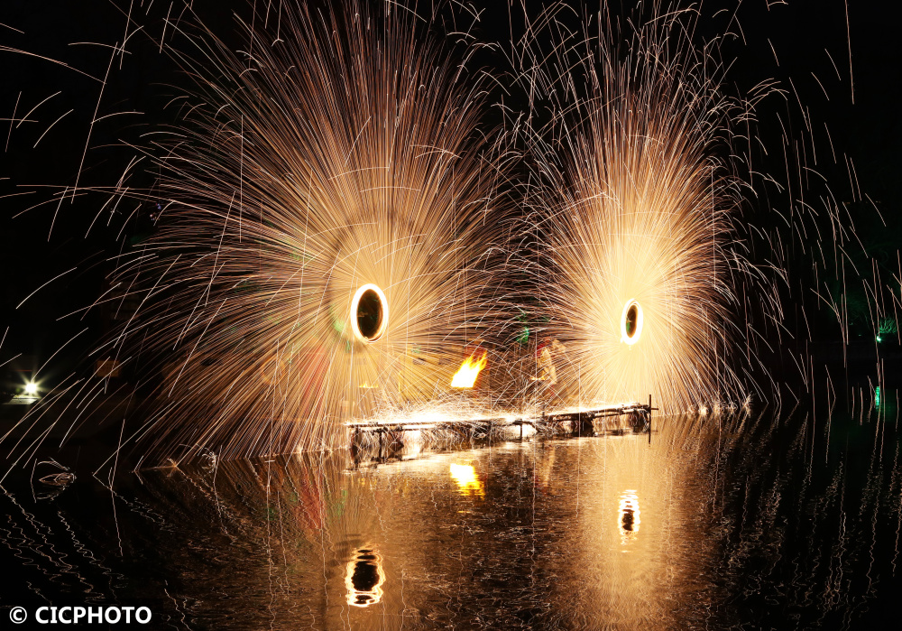 市灞陵桥景区,民间艺人在表演非遗技艺"打铁花"之"风火轮"民俗活动