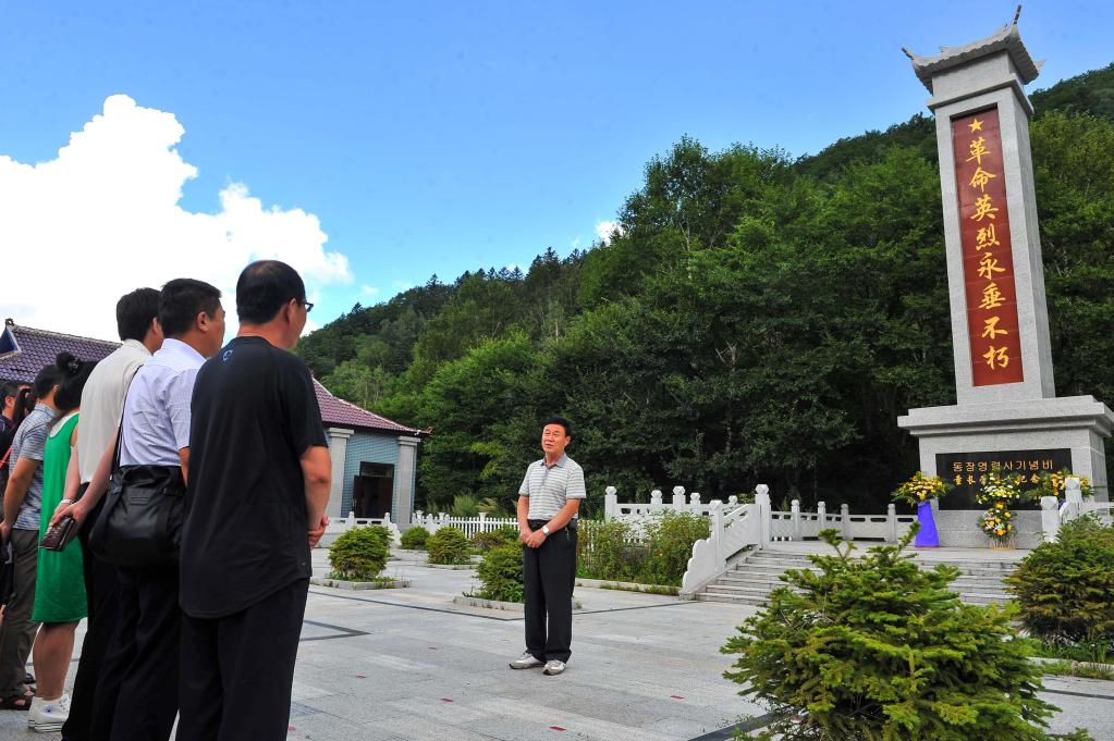 金春燮在童长荣烈士墓地为参观者讲解抗战事迹(2015年8月13日摄.