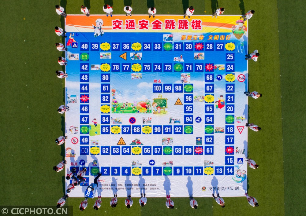 局交警大队民警和城南实验小学的学生们一起玩"交通安全跳跳棋"游戏