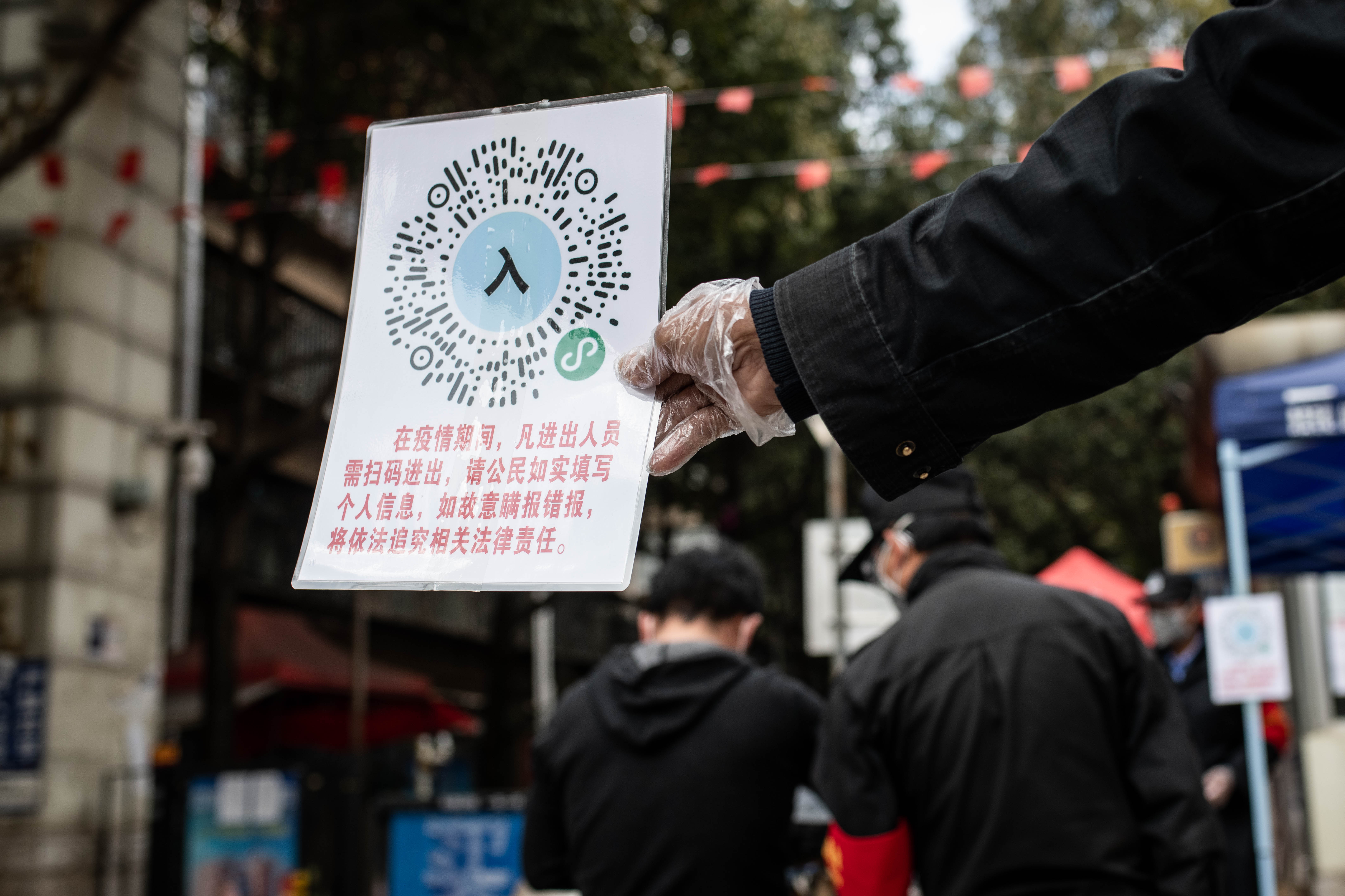 2月15日,在云南省昆明市怡园小区门口,工作人员引导市民扫码出入