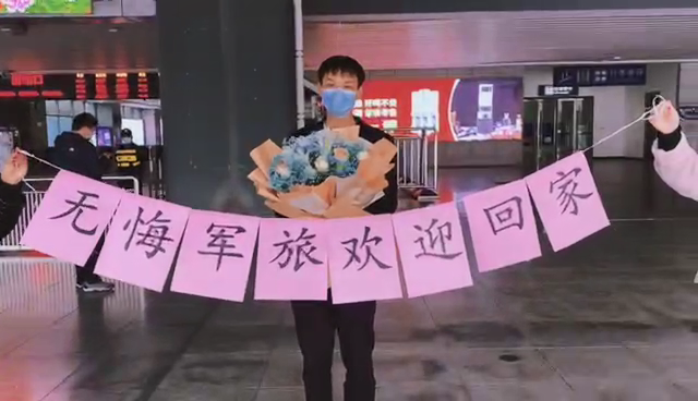 打着横幅手捧鲜花,接老婆退伍回家