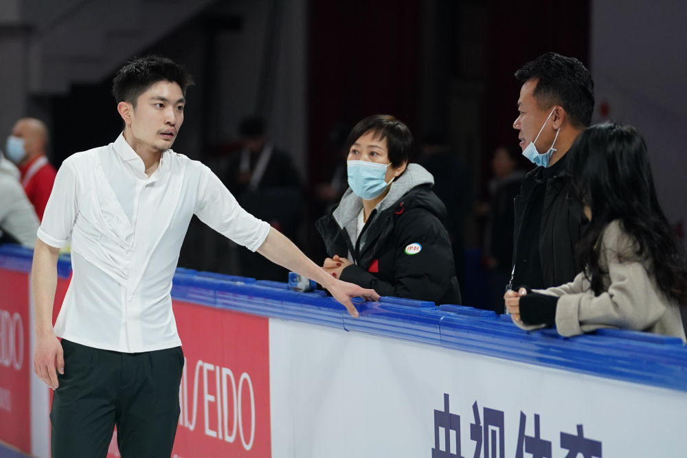 中国男子单人滑选手闫涵(左一)在赛前训练中与中国花样滑冰队总教练赵