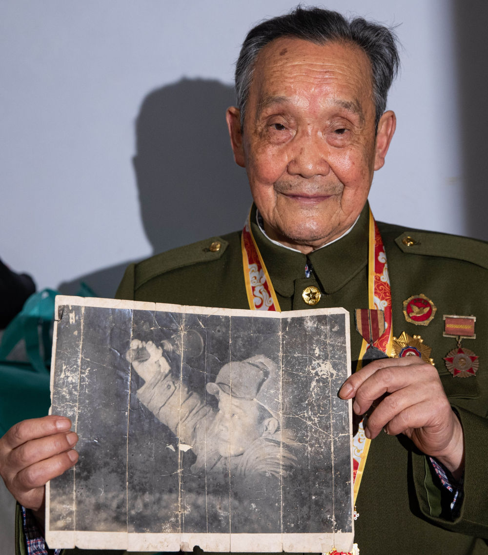 在四川省南充市,志愿军老战士邓彰德展示刊登有他照片的老画册(10 月3