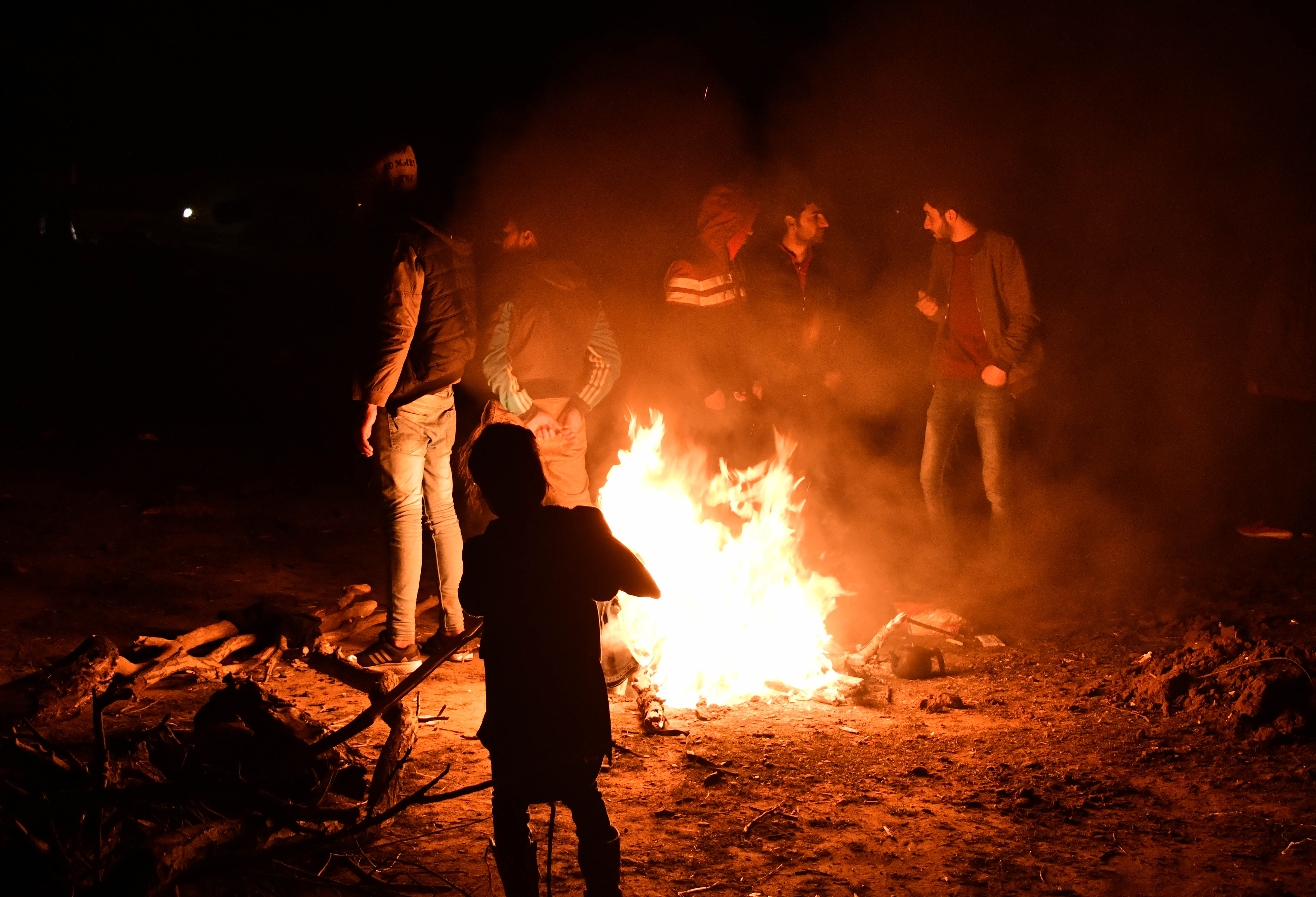 埃迪尔内省靠近希腊的边界地带,一些非法移民在户外点燃篝火取暖