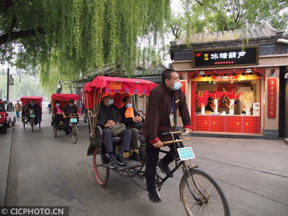 以上图片:2020年10月20日,游客乘坐人力客运三轮车在北京什刹海风景区