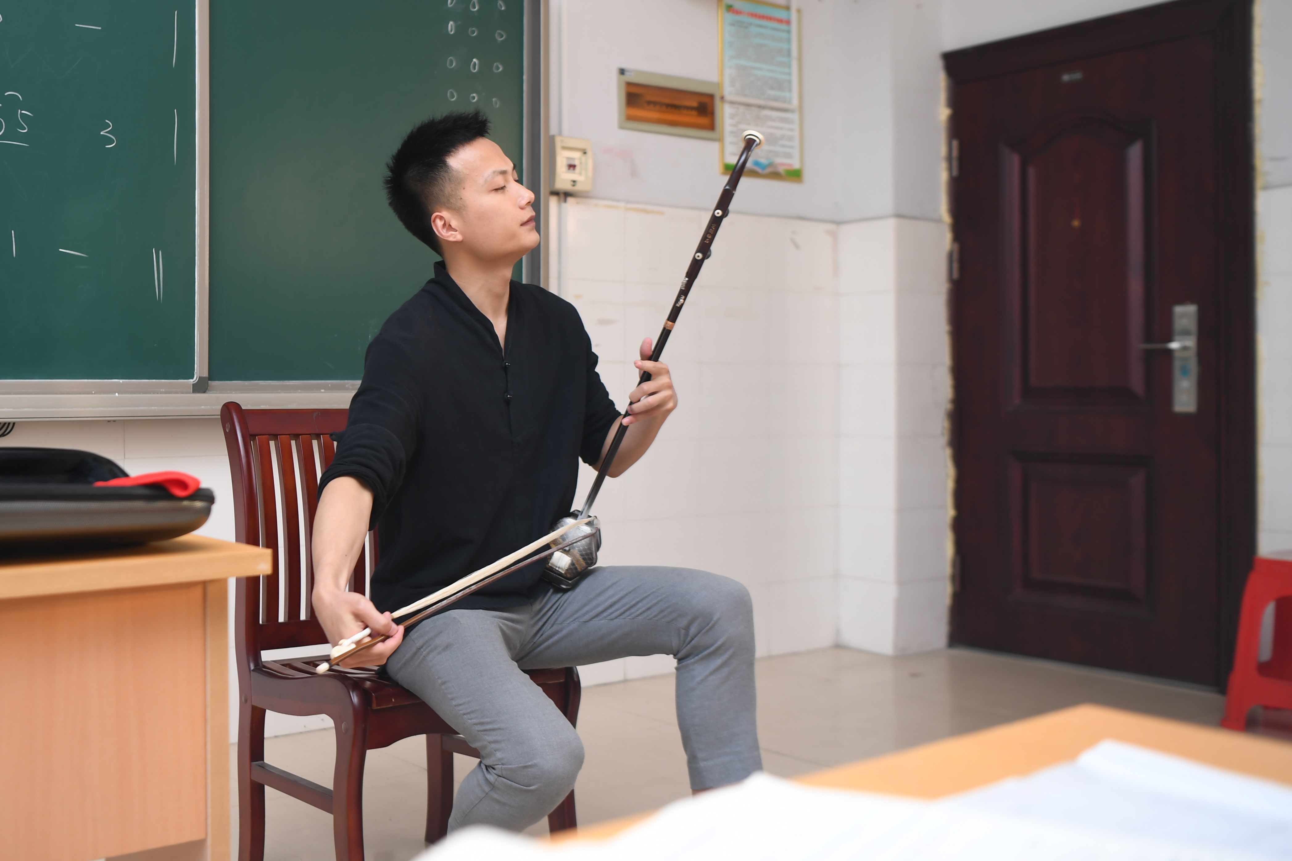 在湖南省湘西土家族苗族自治州,戴发在泸溪县第五中学教室内演奏二胡
