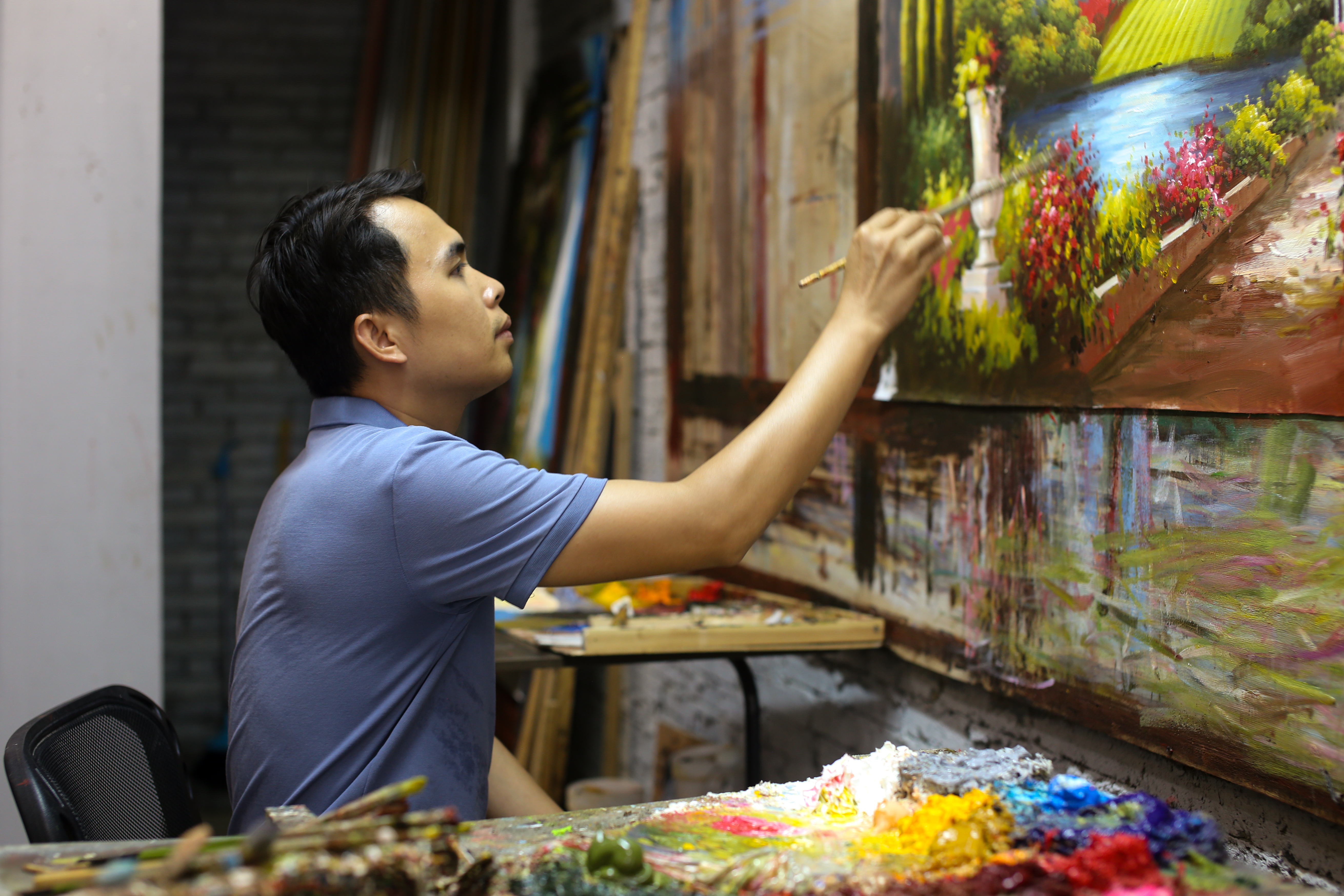 9月6日,屯昌油画步行街画师邓培聪正在"美约画廊"里作画.